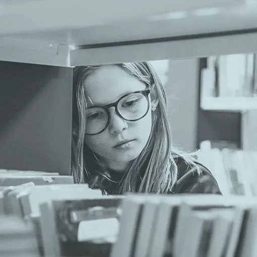 Girl browsing through books at the library